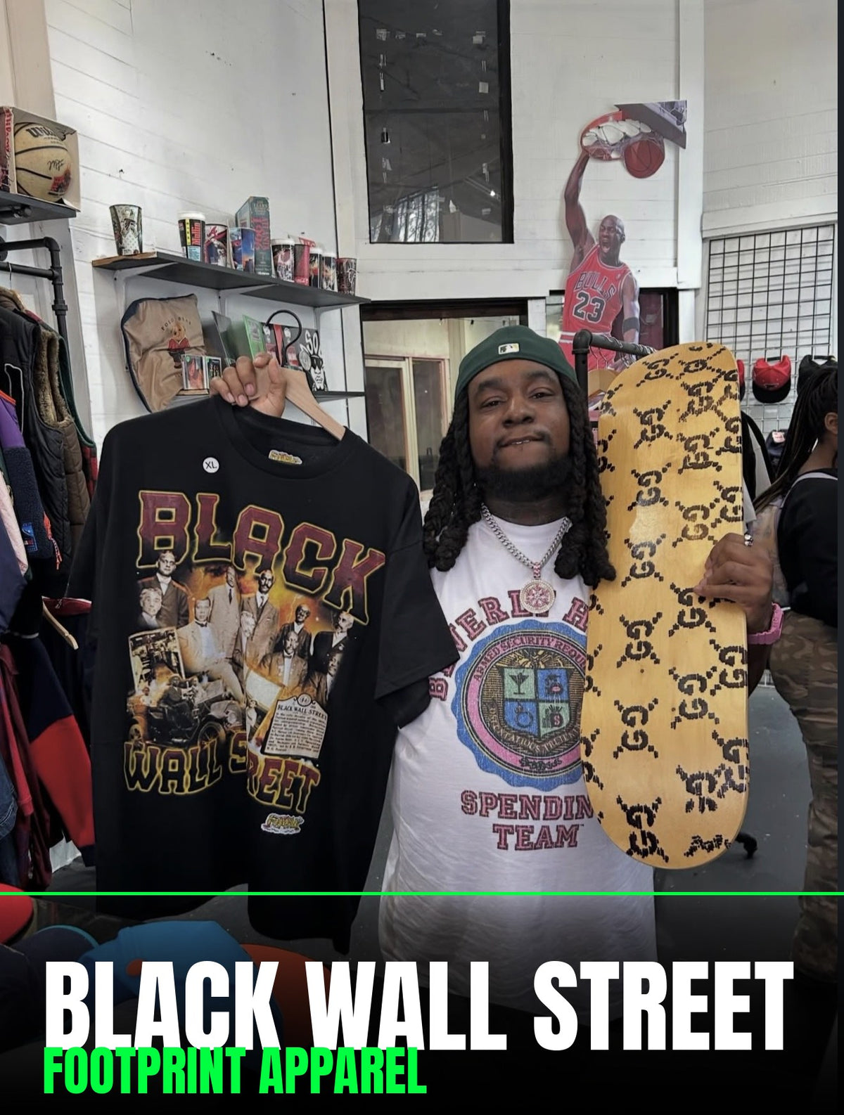 Man in the Footprint Apparel store holding up a Footprint Apparel BLACK WALL STREET tee