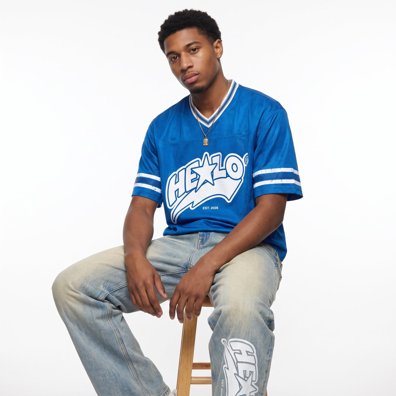 Footprint Apparel — man wearing the blue HE★LO jersey and HE★LO jeans on a white studio background