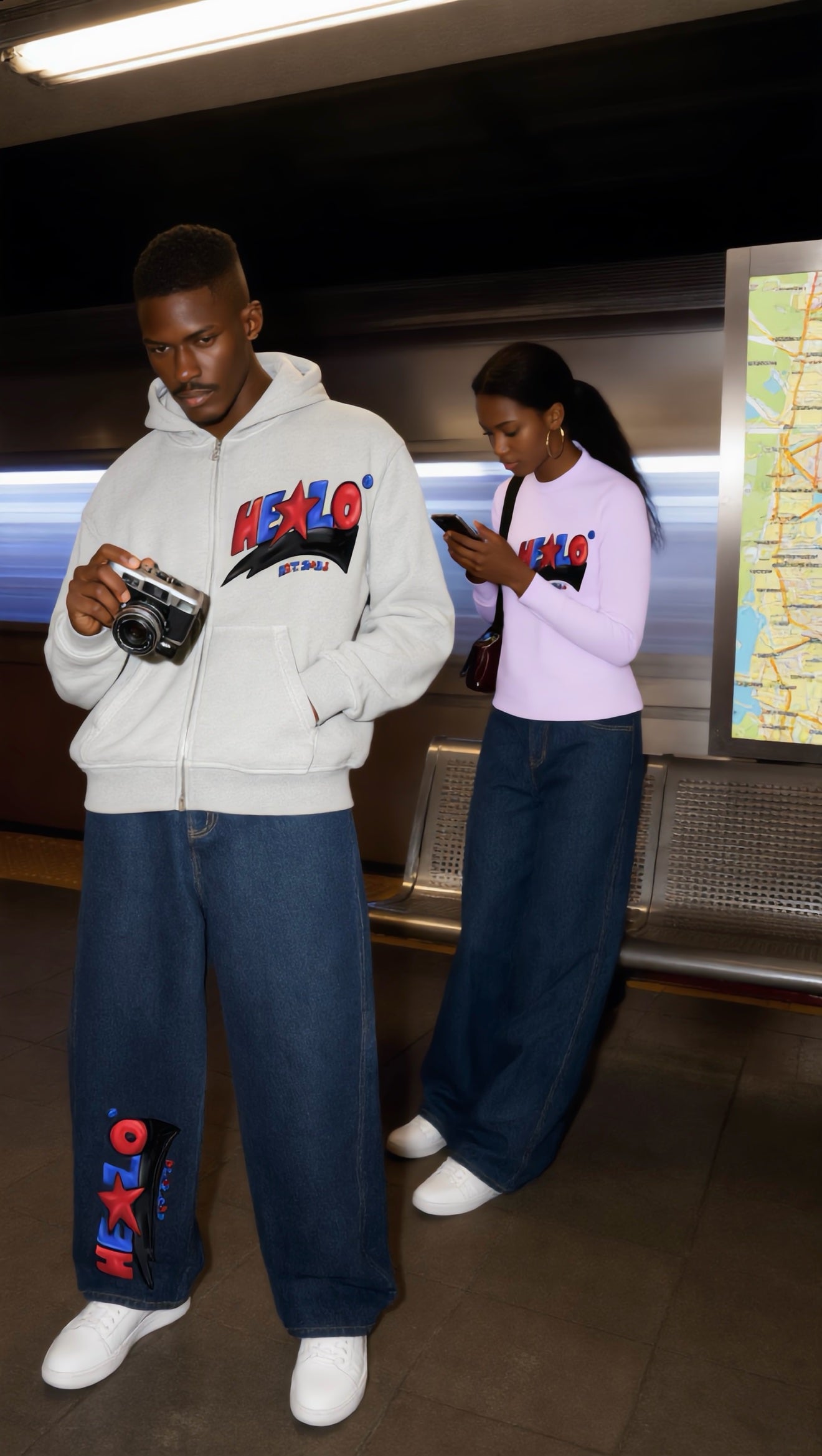 Footprint Apparel men's and women's streetwear — man in a white HE★LO zip hoodie and woman in a light pink top together on a subway platform