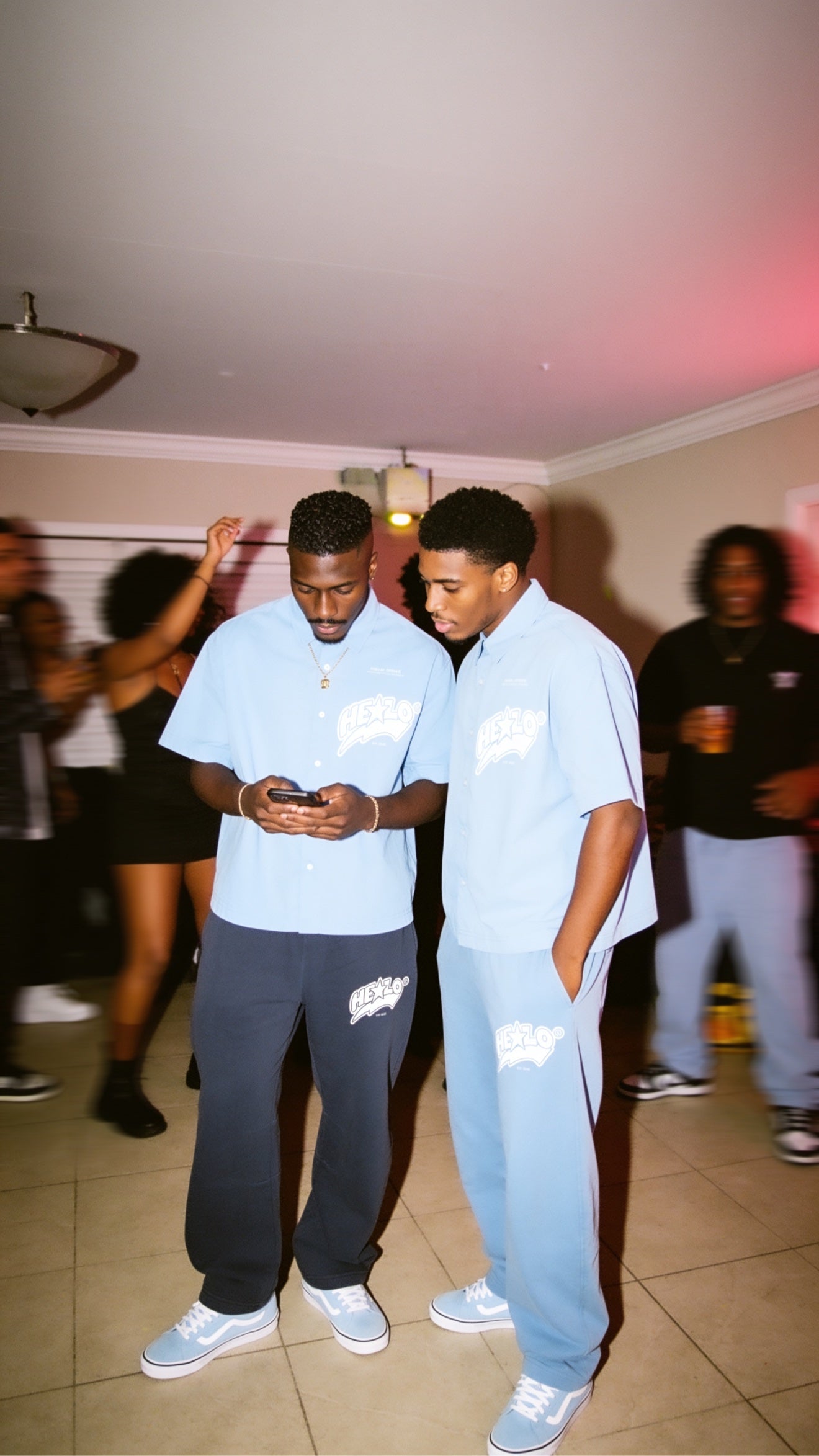 Two models in light blue HELLO sets at a night party