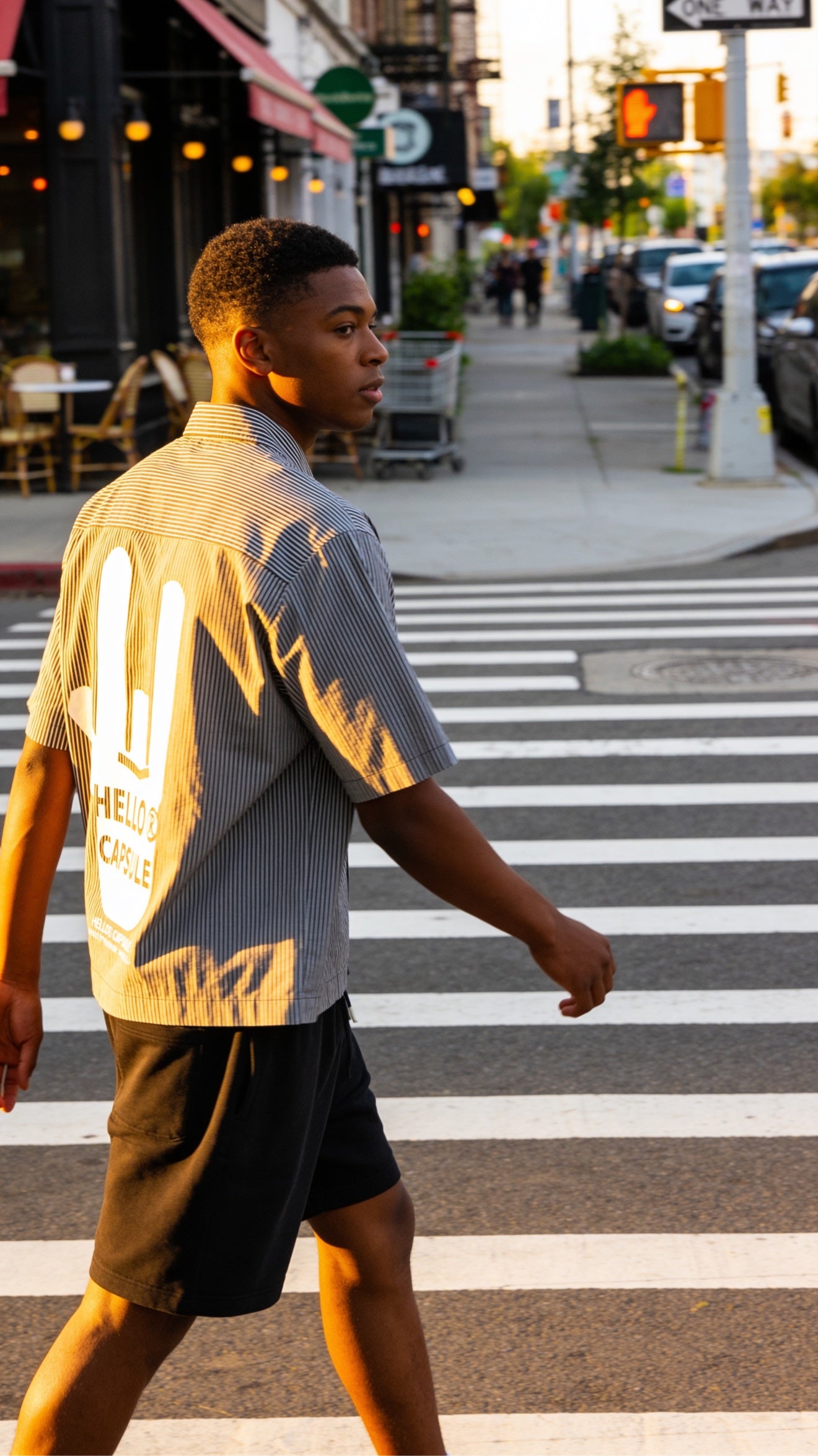 HELLO capsule shirt crossing the street at sunset